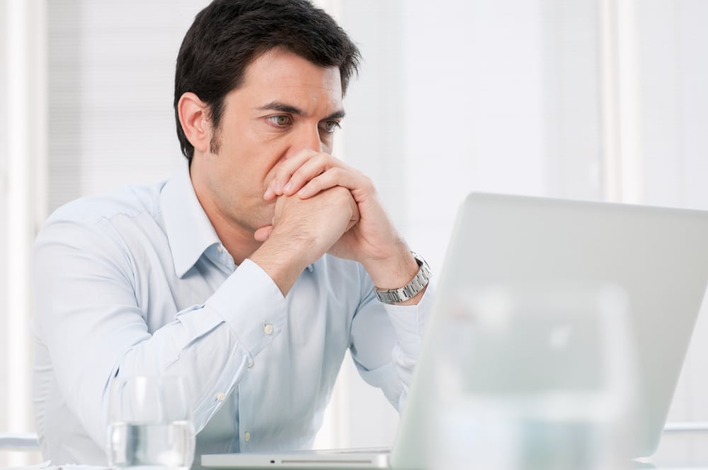 Does a vasectomy hurt? Pensive man researching vasectomies with a worried expression
