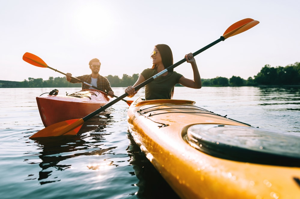 A couple row red and yellow kayaks on a lake in DFW.
