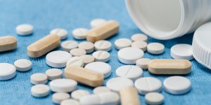 Supplements (possibly to treat ED) are poured out onto a blue background.